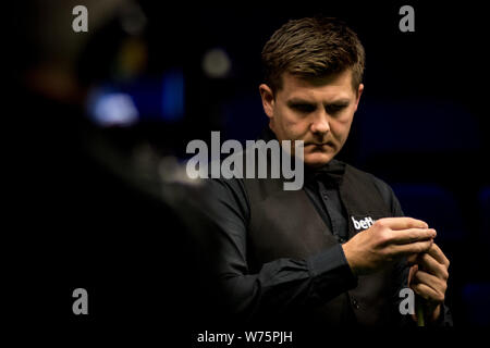 Ryan Jour de galles les craies son cue qu'il estime un shot à Li Hang de Chine dans leur quatrième match au cours de la 2017 Championnat du Royaume-Uni Betway snooker Banque D'Images