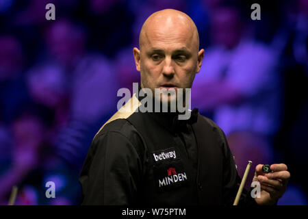 Mark King of England les craies son cue qu'il estime un shot à John Higgins, de l'Écosse dans leur quatrième match au cours de la 2017 Champions Royaume-uni Betway Banque D'Images