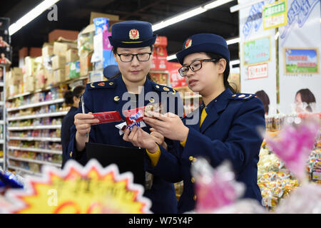 Les agents d'application de la loi chinoise vérifier la qualité des biscuits dans un supermarché dans la région de Shijiazhuang, province de Hebei en Chine du nord, le 27 décembre 2017. Banque D'Images