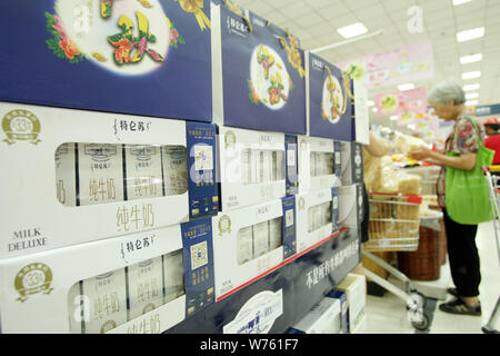 --FILE--un client chinois marche dernières cartouches de lait Mengniu dans un supermarché de luxe à Shanghai, Chine, le 2 septembre 2014. Le géant des produits laitiers chinois Meng Banque D'Images