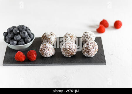 Des boules d'énergie avec la noix de coco. Des aliments sains pour les enfants et les sucreries vegan, substitut. L'énergie biologique sain balles faites avec les dates, les pruneaux, rais Banque D'Images