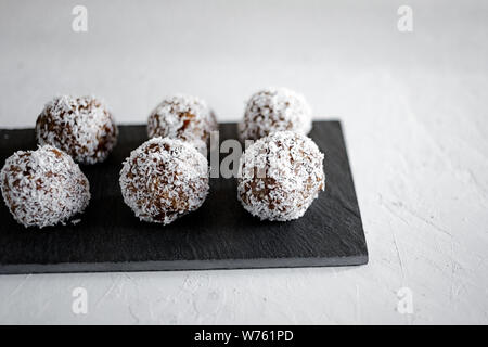 Boules d'énergie maison avec noix de coco. Nourriture saine pour les enfants et les végétaliens, les bonbons se substituent. Boules d'énergie organique saine faites avec des dates, pruneaux. Banque D'Images