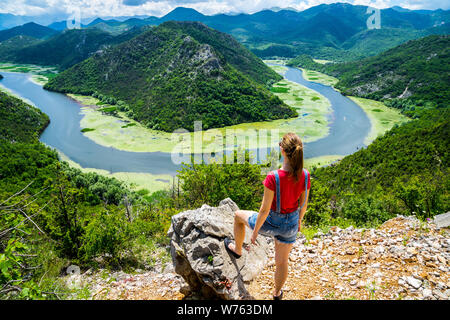 Le Monténégro, magnifique jeune femme aux cheveux longs debout à roche au-dessus de l'eau de la rivière crnojevica bend dans green canyon national park lac Skadar nature sc Banque D'Images