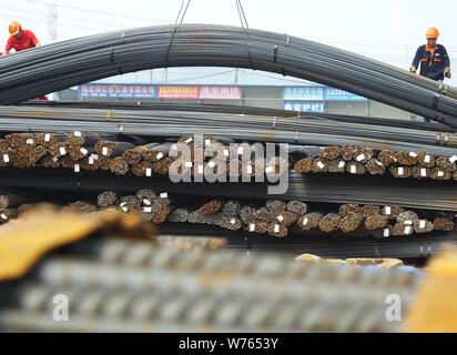 --FILE--Un travailleur chinois dirige une grue pour soulever les barres d'armature en acier pour être exporté à un marché de l'acier à Yichang city, le centre de la Chine Hubei de bauvin Banque D'Images