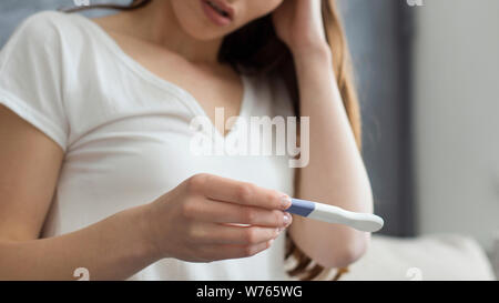 Portrait of woman holding test de grossesse déçu Banque D'Images