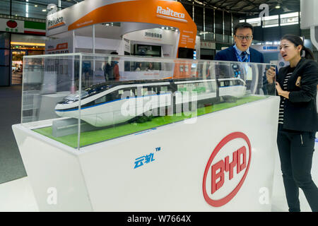 --FILE--visiteurs d'oeil à un modèle train monorail Surnommé 'SkyRail' sur le stand du constructeur automobile électrique BYD lors d'une exposition à Shanghai, Chine, 23 nov. Banque D'Images