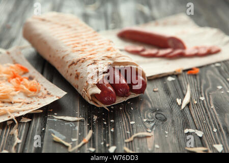 Saucisses épicées dans le pain pita sur une table en bois Banque D'Images