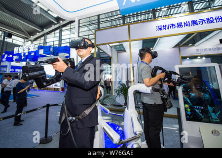 Les visiteurs d'essayer la réalité virtuelle (VR) pour jouer un jeu électronique à la China Hi-tech Fair 2017 dans la ville de Shenzhen, au sud du Guangdong prov Banque D'Images