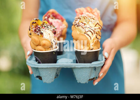 Hong Kong quatre tasses en gaufre livraison de nourriture dans la main de femme Banque D'Images