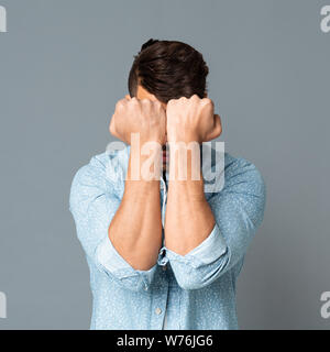 Hispanic Man Holding Hands Punch Blocage sur fond gris Banque D'Images