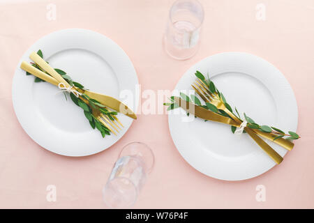 Table de fête pour célébrer l'événement ou le dîner en famille avec deux plaques d'or et couverts. Haut de la vue, télévision lay. Banque D'Images