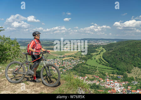 Nice senior woman with electric vtt, à la recherche de la vue sur le Jura souabe jusqu'à la vaste plaine de Baden Württemberg, Allemagne Banque D'Images