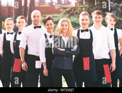 Un grand groupe de serveurs et de serveuses en plein air se tenir l'un après l'autre Banque D'Images