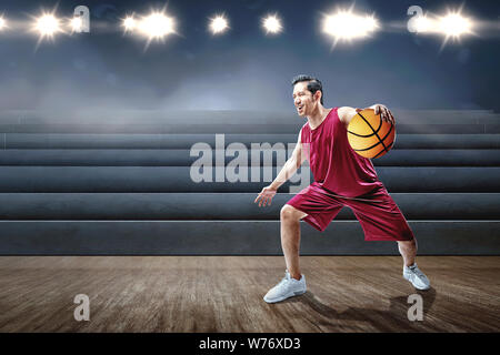 Joueur de basket-ball homme asiatique jouant au basket-ball sur le terrain de basket en salle Banque D'Images