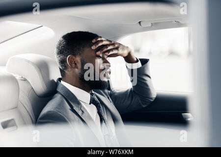 Contrarié fatigué businessman sitting in car, penser à rupture Banque D'Images