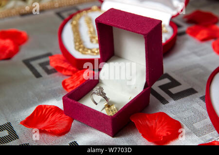 La bague rouge .boîte de bague de fiançailles en or dans une boîte en forme de coeur et des roses Banque D'Images