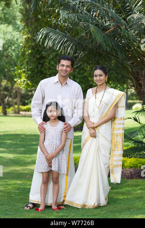 South Indian family standing together in a lawn Stock Photo