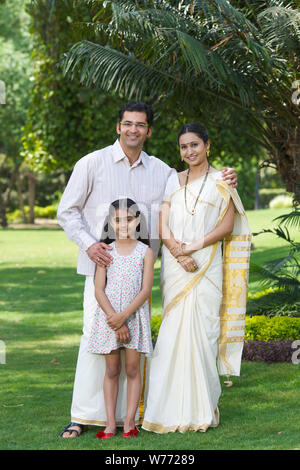 South Indian family standing together in a lawn Stock Photo