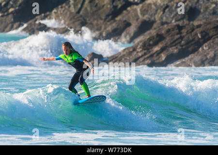 Une femelle à surfer une vague de Fistral Newquay en Cornouailles. Banque D'Images