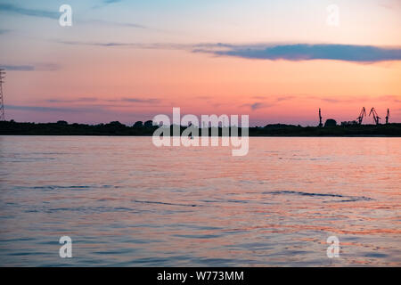 Coucher de soleil sur la digue de la rivière Amur à Khabarovsk. Le coucher de soleil sur l'horizon. Le remblai est éclairé par des lanternes. Banque D'Images