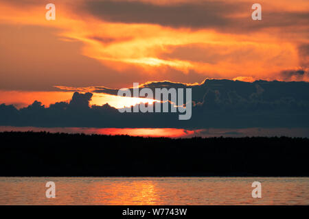 Coucher de soleil sur la digue de la rivière Amur à Khabarovsk. Le coucher de soleil sur l'horizon. Le remblai est éclairé par des lanternes. Banque D'Images