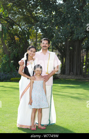 South Indian family standing together in a lawn Stock Photo