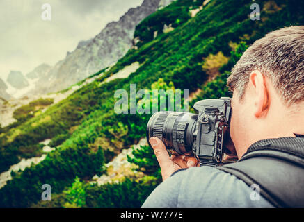 Photographe homme tenant une caméra dans une forêt. Banque D'Images