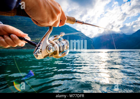 Pêche à la femme sur la canne à pêche spinning en Norvège. La pêche en Norvège est une façon d'embrasser le mode de vie local. D'innombrables lacs et rivières et d'une ampleur Banque D'Images