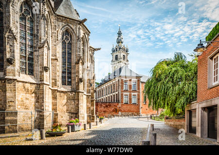 Rue Pavée avec église et beffroi en wallon centre ville de Mons, Hainaut, Belgique. Banque D'Images