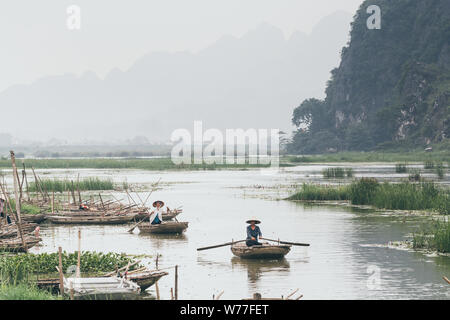 Ninh Binh, Vietnam - Mai 2019 : dans un bateau à rames en bois en passant par Trang An nature park. Banque D'Images