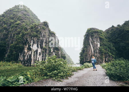 Young blonde woman surplombant les montagnes de calcaire dans la province de Ninh Binh, Vietnam. Banque D'Images