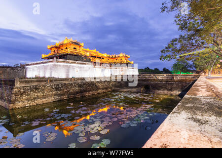 Hue, Vietnam - Juin 2019 : entrée principale de la Cité Interdite Pourpre ville impériale au coucher du soleil, le reflet dans l'eau Banque D'Images