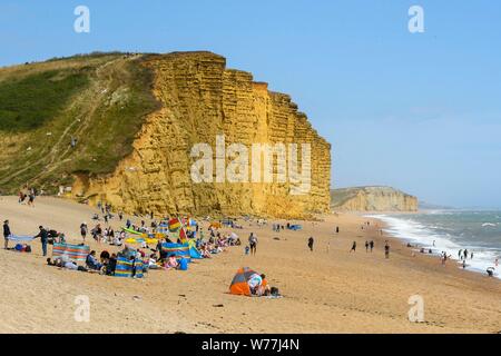 West Bay, Dorset, UK. 5 août 2019. Météo britannique. Vacanciers et baigneurs sur la plage à la station balnéaire de West Bay dans le Dorset par une chaude journée ensoleillée. Crédit photo : Graham Hunt/Alamy Live News Banque D'Images