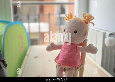 Poupée peluche rose assis sur une table en bois et d'attente Banque D'Images