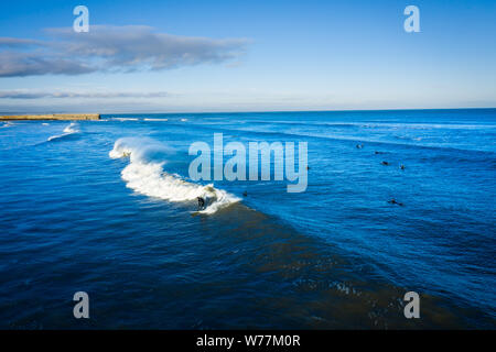 Surfers sur East Sands Beach. Les surfeurs courageux subissent les eaux de la mer du Nord froid brutalement à monter quelques vagues en East Sands Beach. Banque D'Images