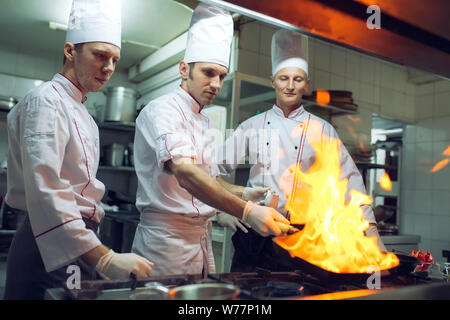 Dans la cuisine. Le feu brûler du gaz est la cuisson à poêle de fer,remuer le feu très chaud. Banque D'Images