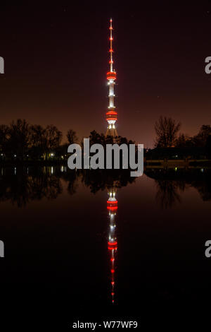 Les lumières de la tour de télévision se reflètent dans l'eau du lac. Photo de nuit. Banque D'Images