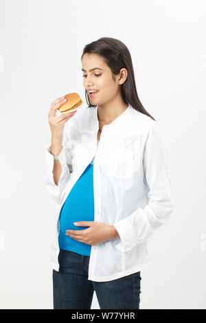 Pregnant woman eating hamburger