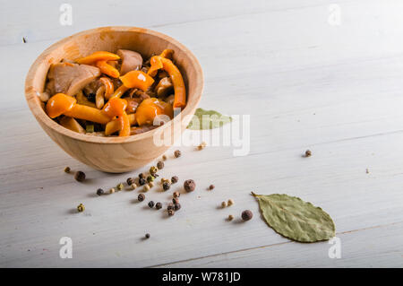 Dans les champignons marinés couverts en bois sur fond blanc avec copie espace Banque D'Images