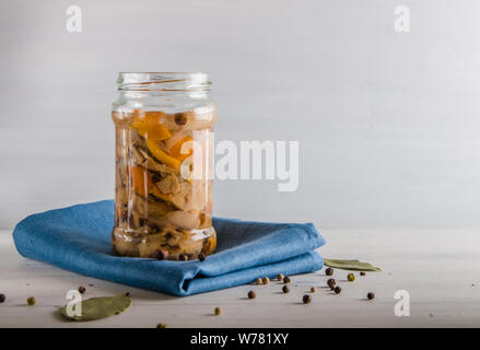 Champignons marinés dans un bocal en verre sur un fond blanc Banque D'Images