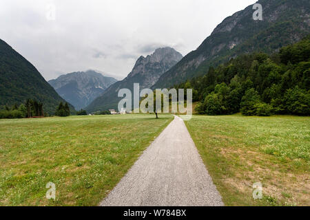 Chemin de terre entre les champs de graminées dans paysage rural, village de l'arrière-plan, la vallée de la soca, Slovénie, Europe Banque D'Images