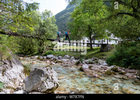 Mère et fils traversant un pont suspendu en bois sur la rivière Soca turquoise tout en randonnée sur le sentier de la soca, Bovec, Slovénie, Europe Banque D'Images