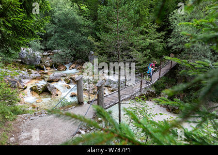 Mère et fils traversant un pont suspendu en bois sur la rivière Soca turquoise tout en randonnée sur le sentier de la soca, Bovec, Slovénie, Europe Banque D'Images