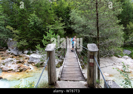 Mère et fils traversant un pont suspendu en bois sur la rivière Soca turquoise tout en randonnée sur le sentier de la soca, Bovec, Slovénie, Europe Banque D'Images