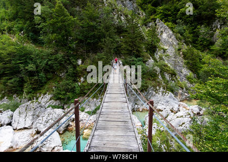 Mère et fils traversant un pont suspendu en bois sur la rivière Soca turquoise tout en randonnée sur le sentier de la soca, Bovec, Slovénie, Europe Banque D'Images