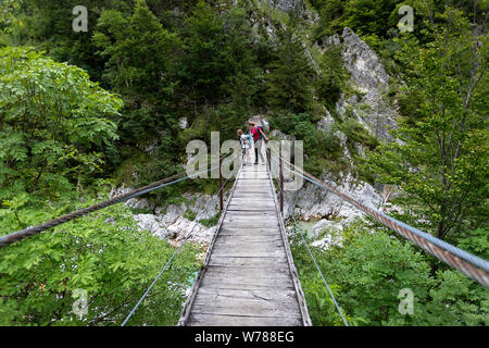 Mère et fils traversant un pont suspendu en bois sur la rivière Soca turquoise tout en randonnée sur le sentier de la soca, Bovec, Slovénie, Europe Banque D'Images