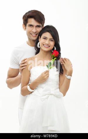 Young man giving a rose to woman and smiling Stock Photo