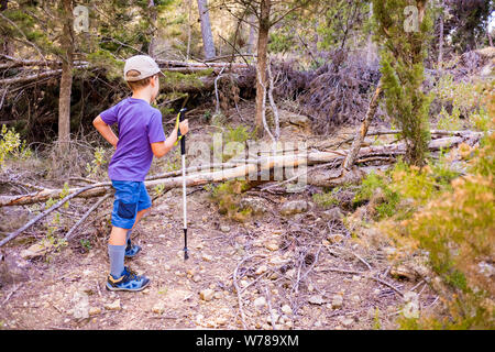 Des sentiers de randonnées randonneur enfant s'appuyant sur un bâton de randonnée vivre une aventure. Banque D'Images