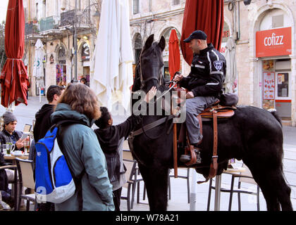 Un cheval belge dans la Police israélienne et un agent de police d'attirer l'attention des piétons à Jérusalem. Banque D'Images