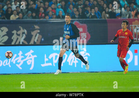Ancien footballeur italien Marco Materazzi, gauche, de coups à jamais la balle pour faire une passe contre un joueur de l'équipe de légendes chinoises toutes les étoiles Banque D'Images